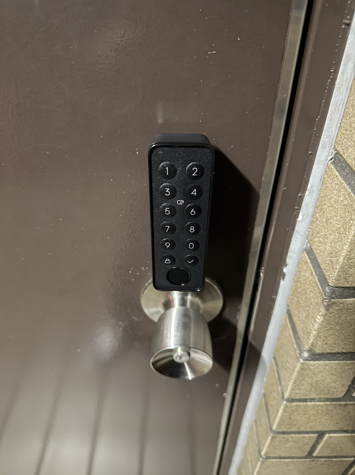 画像 ドア外側に設置した指紋認証パッド。テンキーの数字ボタンと丸ノブが並んでいる