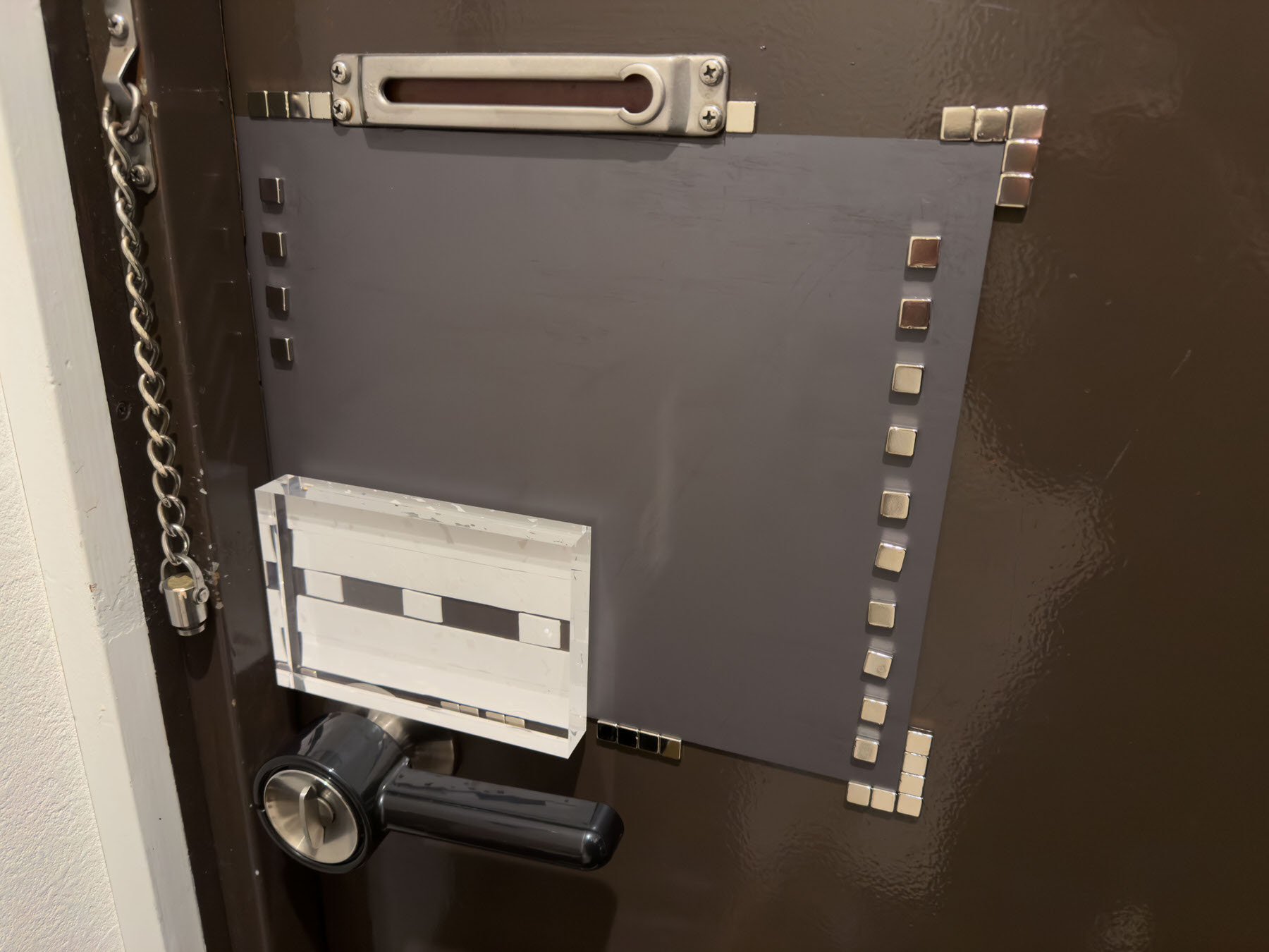 画像 ドア内側にマグネットシートとネオジウム磁石を設置した様子。四隅にネオジウム磁石を配置しアクリルブロックとドアレバーも見える